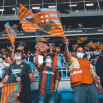 Torcedores do FC Barcelona acenam com bandeiras durante uma partida de futebol.